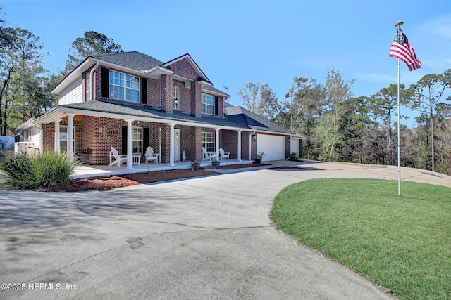view of front of home with a front yard, a garage, and a porch