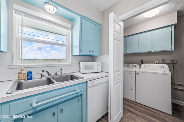 laundry room featuring cabinet space, dark wood-style flooring, separate washer and dryer, and a sink