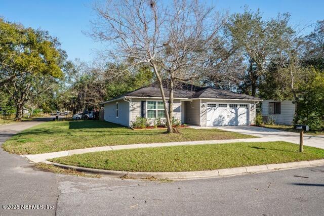 view of front of home with a front yard and a garage