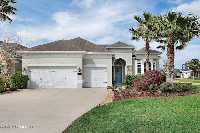 mediterranean / spanish-style house with an attached garage, a shingled roof, driveway, stucco siding, and a front yard