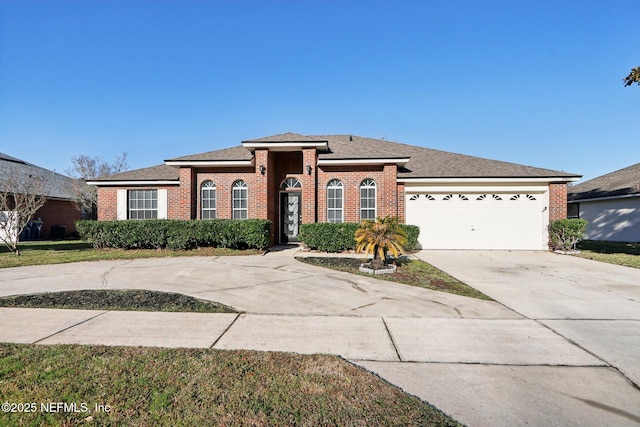 view of front of house featuring a garage, brick siding, and driveway