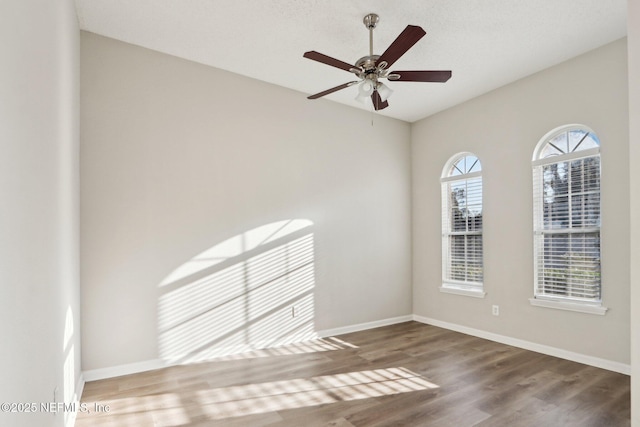 spare room with baseboards, a healthy amount of sunlight, and wood finished floors