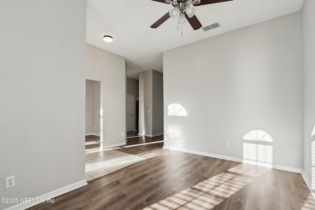 unfurnished room with visible vents, ceiling fan, baseboards, and wood finished floors