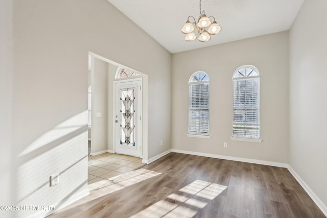 interior space with wood finished floors, baseboards, and a chandelier