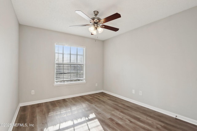 empty room featuring wood finished floors, baseboards, and ceiling fan