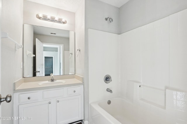 bathroom featuring bathtub / shower combination, vanity, visible vents, and a textured ceiling