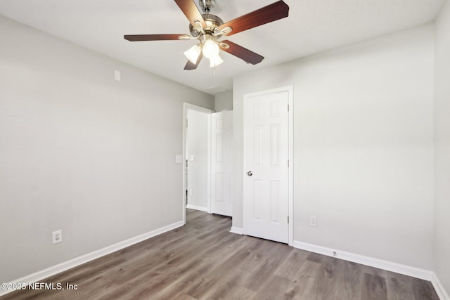 unfurnished bedroom featuring wood finished floors, baseboards, a closet, and ceiling fan