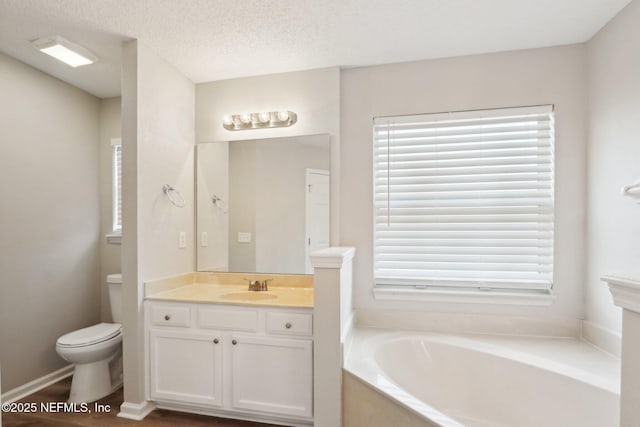 full bathroom with a textured ceiling, a healthy amount of sunlight, a bath, and toilet