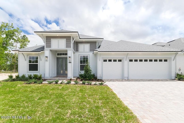 prairie-style home with a front yard and a garage