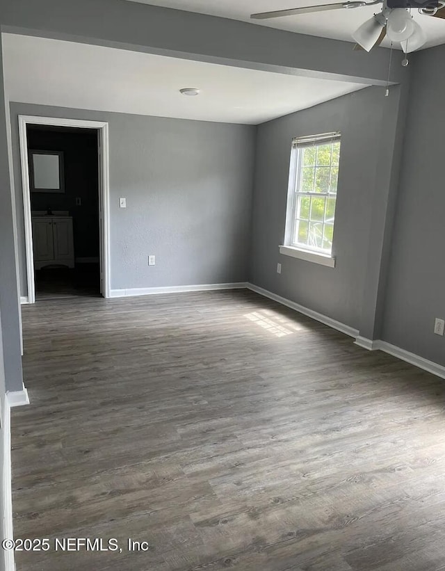 spare room with ceiling fan and dark wood-type flooring