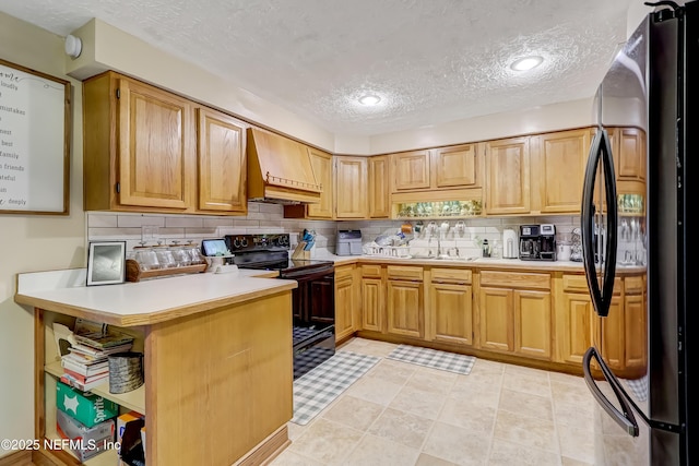 kitchen featuring black appliances, backsplash, custom exhaust hood, and light countertops