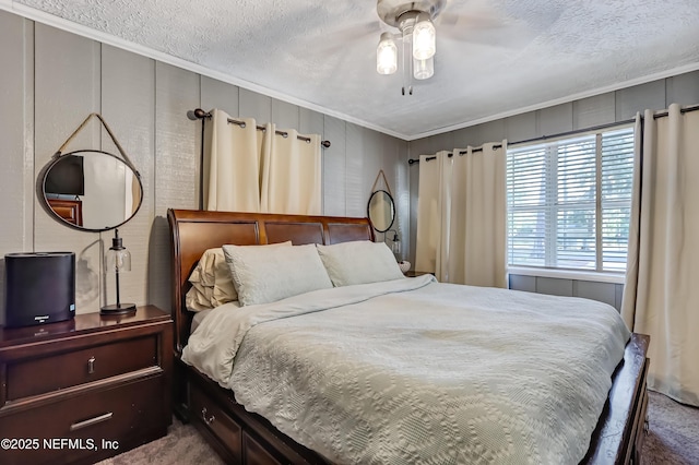 carpeted bedroom featuring ornamental molding, a textured ceiling, and a ceiling fan