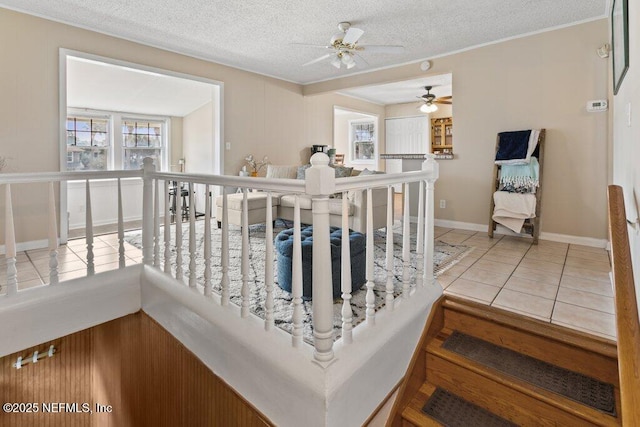 interior space featuring baseboards, a textured ceiling, and tile patterned floors