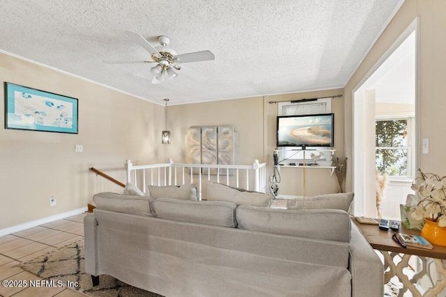 living area with light tile patterned floors, ornamental molding, a textured ceiling, and a ceiling fan