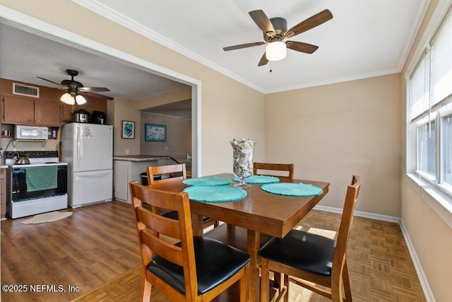 dining room featuring a healthy amount of sunlight, visible vents, and crown molding