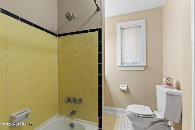 full bathroom with shower / bathtub combination, tile patterned floors, toilet, and baseboards