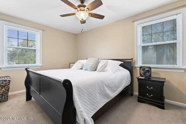 bedroom featuring a ceiling fan, light colored carpet, and baseboards