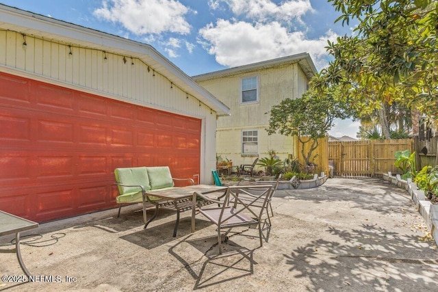 view of patio featuring driveway and fence