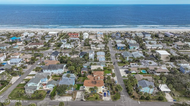 drone / aerial view with a residential view, a water view, and a beach view