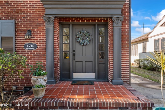 view of exterior entry with brick siding