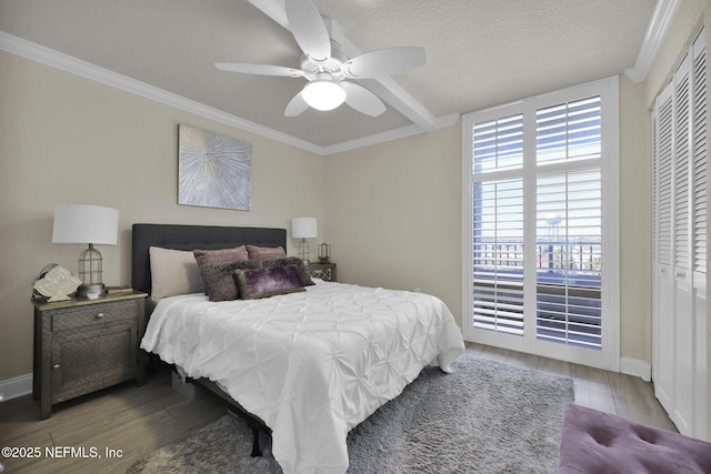 bedroom with wood finished floors, crown molding, baseboards, a ceiling fan, and a textured ceiling