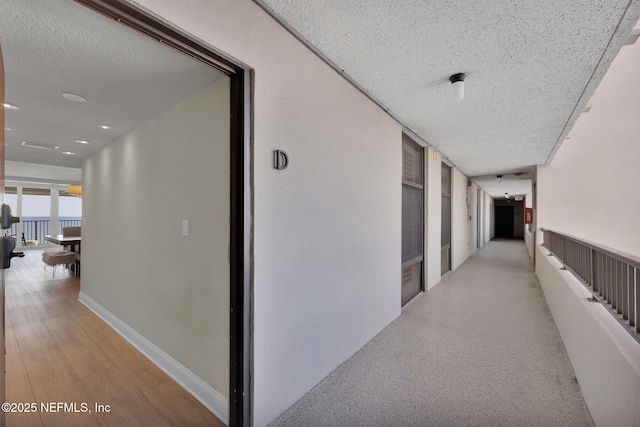 hall featuring a textured ceiling and recessed lighting