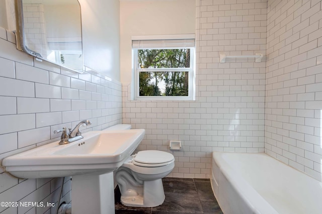 full bathroom with tile walls, toilet, and a bath