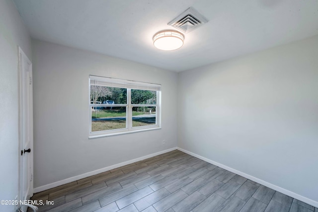 unfurnished room with light wood-style floors, visible vents, and baseboards