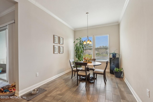 dining space featuring crown molding, baseboards, and wood finished floors