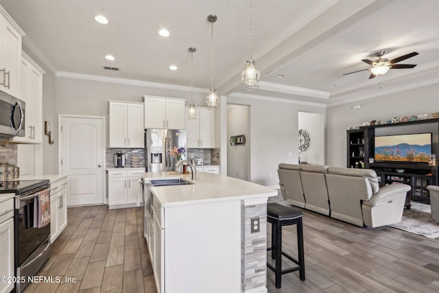 kitchen featuring stainless steel appliances, visible vents, decorative backsplash, wood tiled floor, and open floor plan