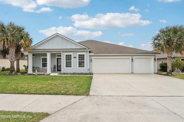 view of front of home with driveway, a garage, a porch, board and batten siding, and a front yard