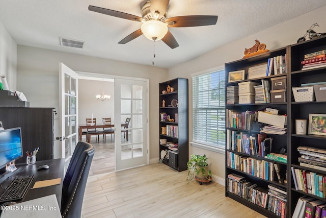 office area featuring ceiling fan with notable chandelier, a textured ceiling, wood finished floors, and visible vents