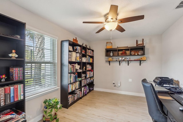 office space featuring light wood-type flooring, visible vents, ceiling fan, and baseboards