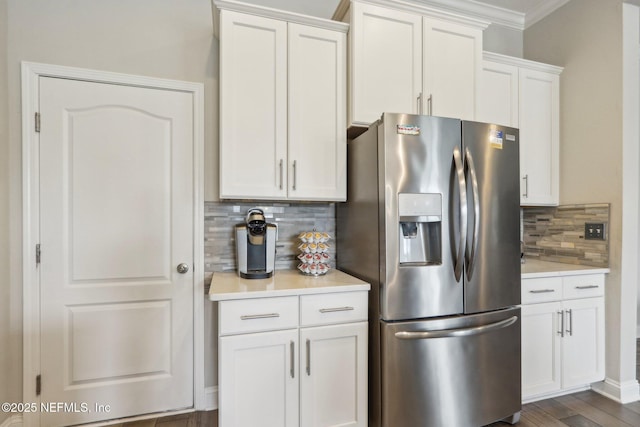 kitchen featuring white cabinetry, light countertops, stainless steel refrigerator with ice dispenser, tasteful backsplash, and crown molding