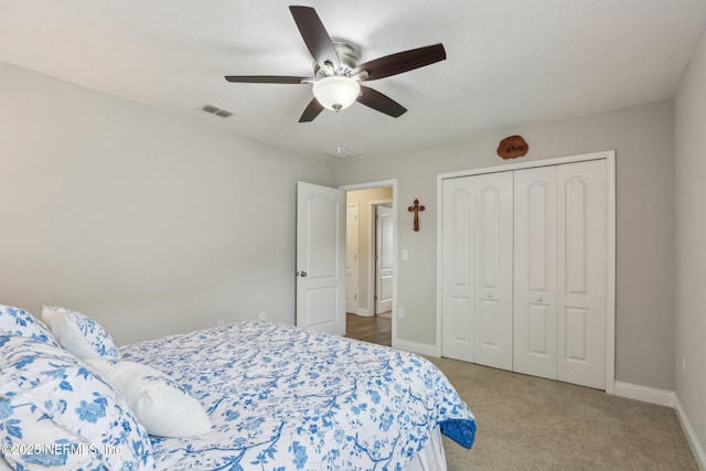 carpeted bedroom featuring a closet, visible vents, ceiling fan, and baseboards