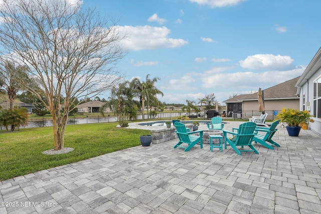 view of patio featuring a water view, fence, and a fire pit