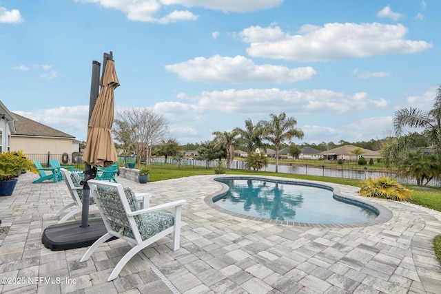 view of pool with a patio, a water view, fence, and a fenced in pool