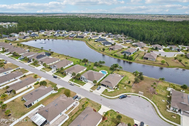 aerial view with a residential view, a water view, and a view of trees