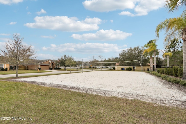 view of community with volleyball court and a yard