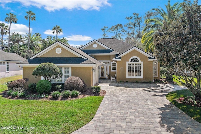 view of front of home with a front lawn, stucco siding, and driveway