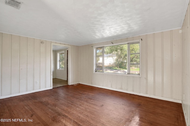 spare room with dark wood-style flooring and visible vents