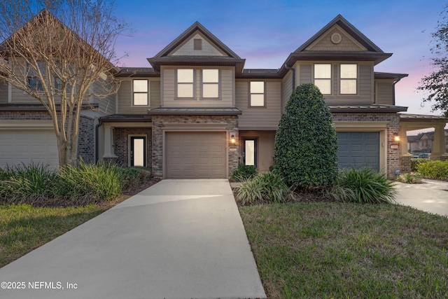 view of front of house featuring a garage, driveway, a front lawn, and stone siding