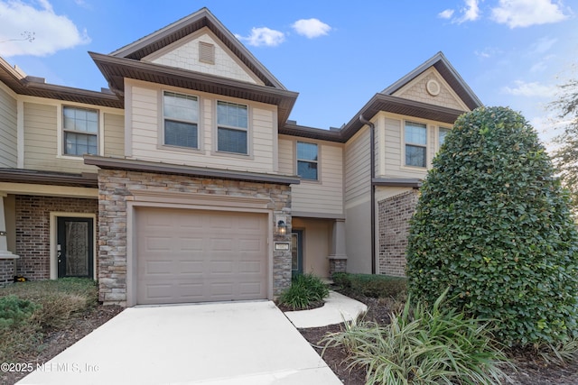 multi unit property featuring a garage and concrete driveway