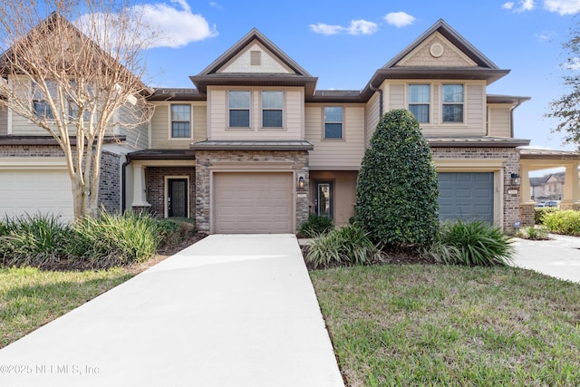 view of front of home with a garage, driveway, a front lawn, and stone siding