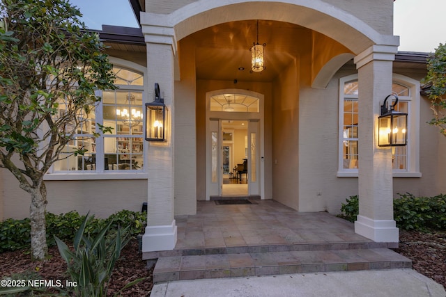 doorway to property featuring stucco siding and brick siding