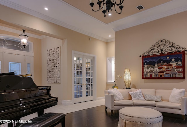 living room with visible vents, crown molding, and an inviting chandelier