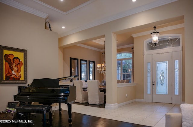 foyer with recessed lighting, ornamental molding, wood finished floors, a chandelier, and baseboards