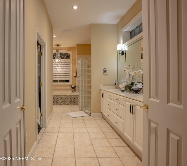 full bath with baseboards, tiled shower, a bath, tile patterned floors, and double vanity