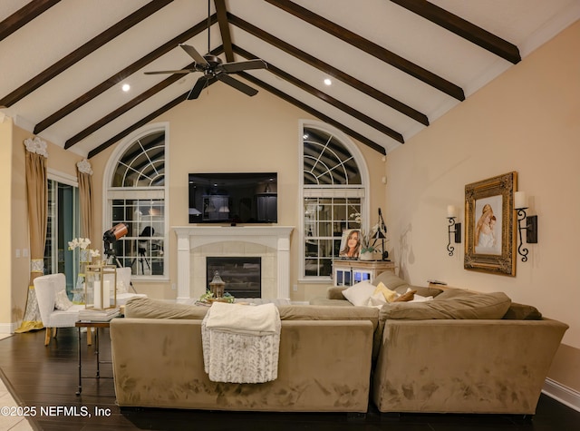 living area with high vaulted ceiling, wood finished floors, beamed ceiling, and a tile fireplace