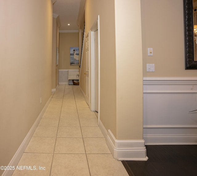 corridor with crown molding, baseboards, and tile patterned floors